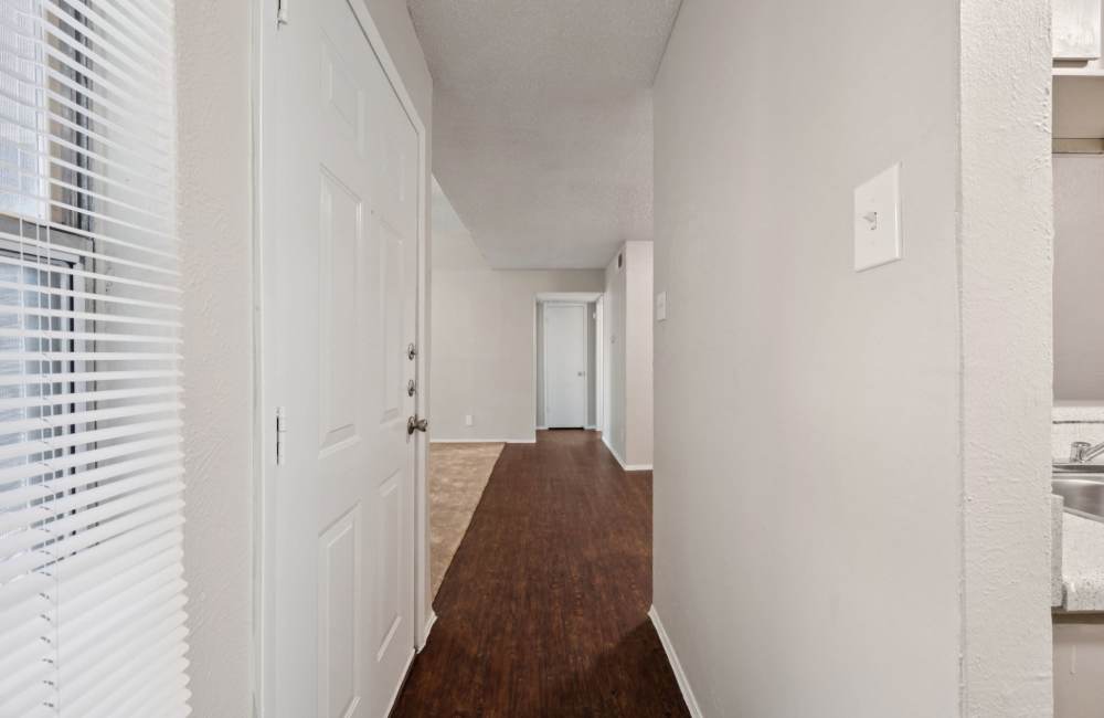 View of living room from kitchen with wooden flooring at Sleepy Hollow in Arlington, Texas