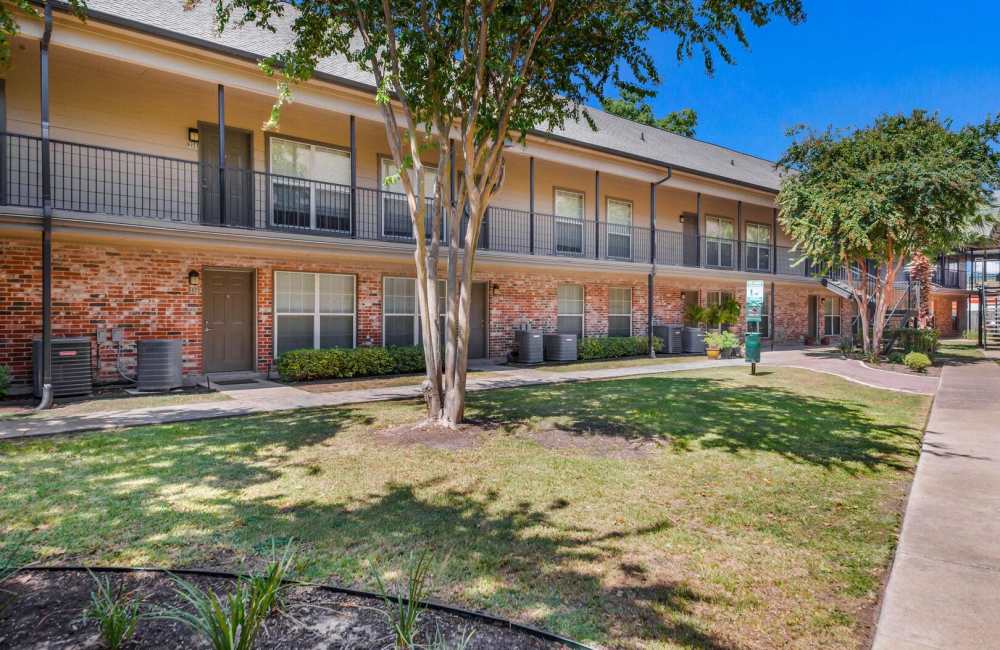 Exterior view of the apartment with green lawn at The Lowell at Mueller in Austin, Texas