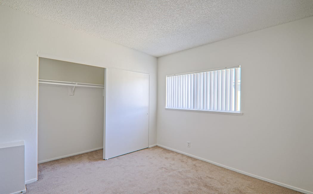 Large bedroom with plenty of space to make it your own at Woodlands West Apartment Homes in Lancaster, CA