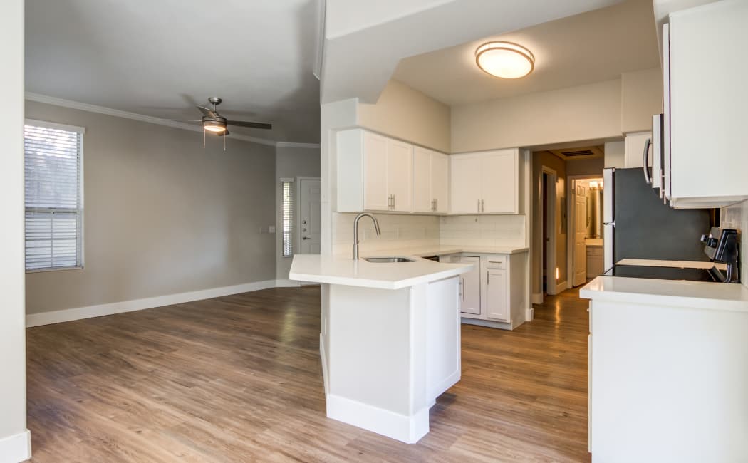 View of living area and modern kitchen in open-concept floor plan at Lumiere Chandler in Chandler, Arizona