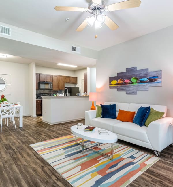 An apartment living room with a couch, coffee table and rug at Reagan Crossing in Covington, Louisiana