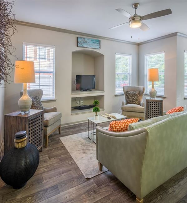 An apartment living room with a couch and lamps on side tables at Evergreens at Mahan in Tallahassee, Florida