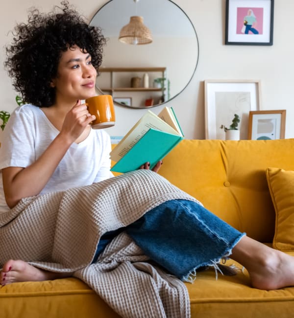 A resident relaxing on her couch at The Lively Indigo Run in Ladson, South Carolina