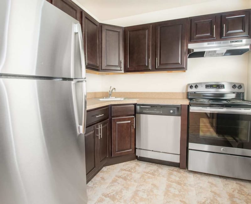 Updated kitchen with stainless steel appliances and cherry wood cabinets in an apartment home at Laurel Run Village in Bordentown, New Jersey