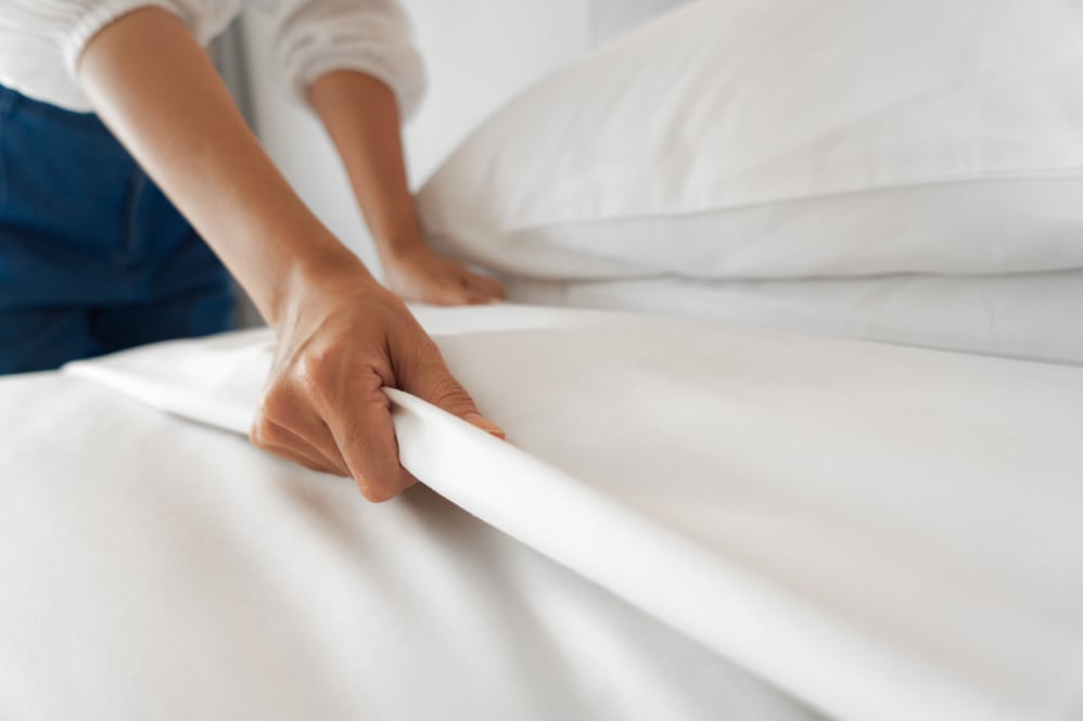 Woman making the bed at Eagleview Landing in Exton, Pennsylvania