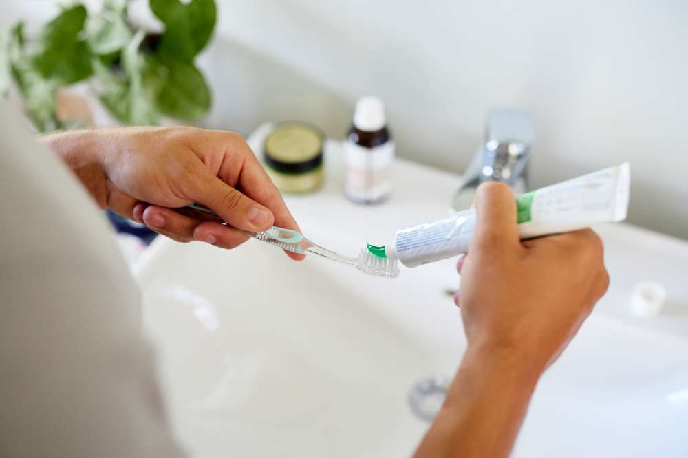Man brushing teeth at modern bathroom sink at The Residences at Talcott in Weatogue, Connecticut