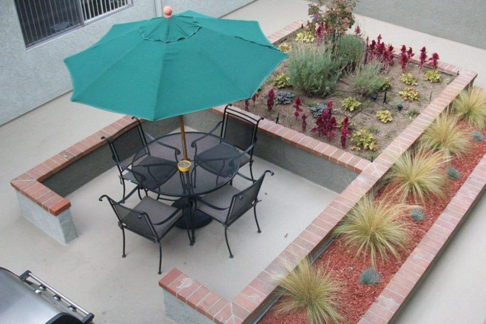 Courtyard BBQ area with umbrella covered table and chairs at The Ridgeview in Northridge, CA