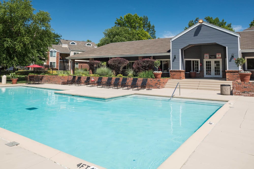 A swimming pool with lounge chairs at Sunbrook Apartments in Saint Charles, Missouri