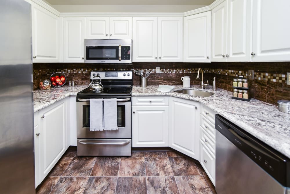 Fully equipped kitchen with white cabinetry and stainless steel appliances at Abrams Run Apartment Homes in King of Prussia, Pennsylvania