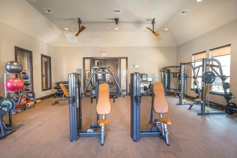 Free weight station in fitness center at The Abbey at Spring Town Center in Spring, Texas