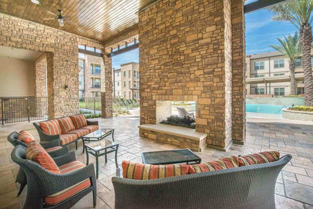 Outdoor lounge area connected to swimming pool at The Abbey at Spring Town Center in Spring, Texas