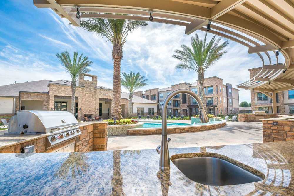 Resort-style pool with bbq setup at The Abbey at Spring Town Center in Spring, Texas