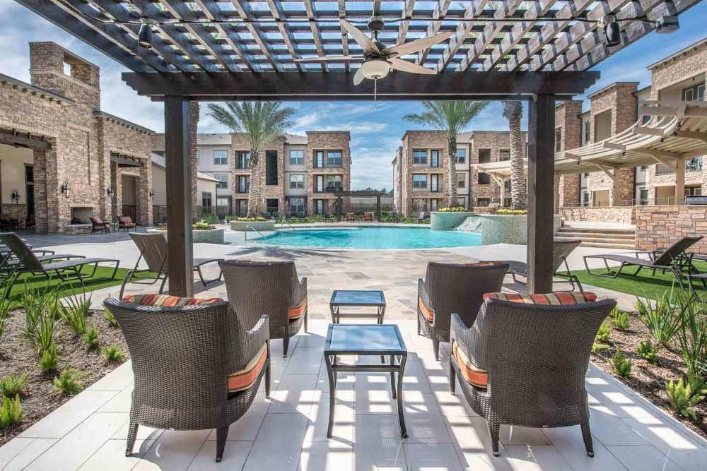 Pool area with lounge seating at The Abbey at Spring Town Center in Spring, Texas