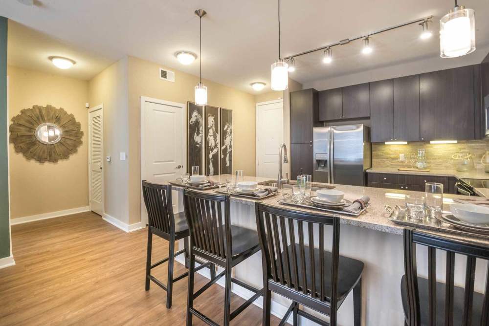 Dining room with close access to fully-equipped kitchen with oven and stove at The Abbey at Spring Town Center in Spring, Texas