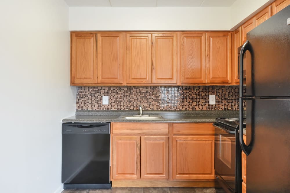 Maple cabinetry featured along with black appliances in recently renovated kitchen at William Penn Village Apartment Homes in New Castle, Delaware