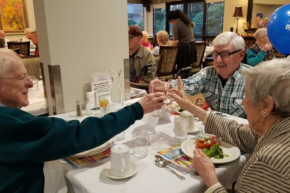 Residents toasting during a delicious meal at Shorewood Senior Living in Florence, Oregon