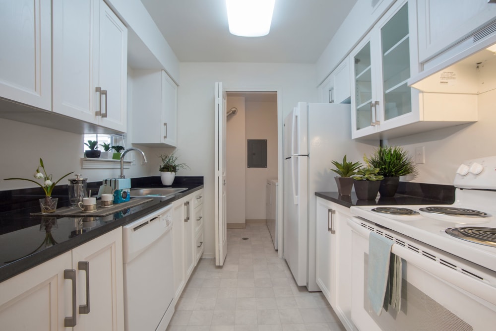 Contemporary kitchen with granite countertops and white cabinetry at Citation Club in Farmington Hills, Michigan