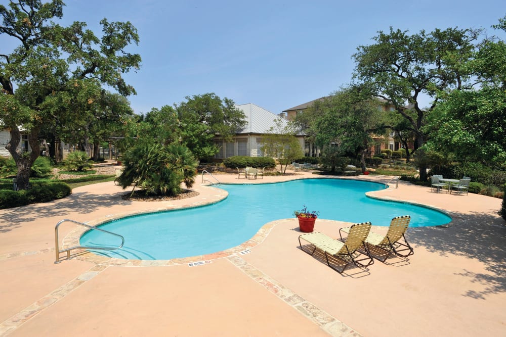 Swimming pool with lounge chairs at The Estates of Northwoods