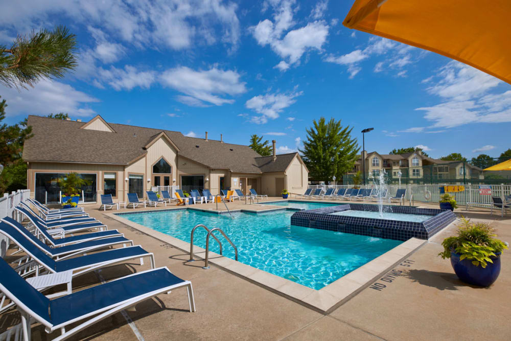 Sparkling swimming pool with an expansive pool deck featuring lounge chairs and a water feature at Briar Cove Terrace Apartments in Ann Arbor, Michigan