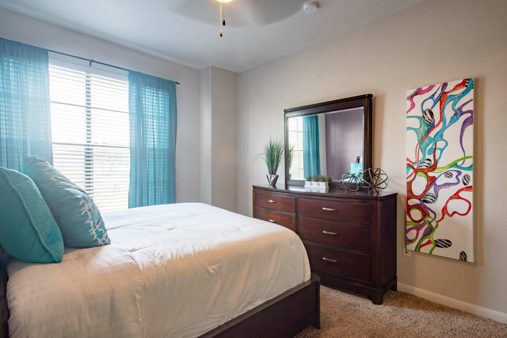 Spacious bedroom with cute blue blinds hanging in the window at The Quarry Townhomes in San Antonio, Texas