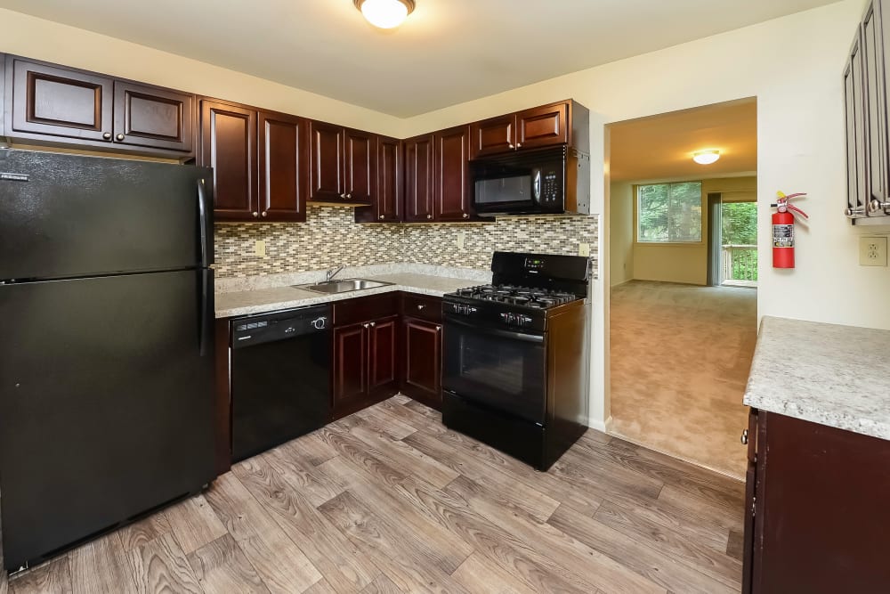 Fully-equipped kitchen with sleek black appliances at Briarwood Apartments & Townhomes in State College, Pennsylvania