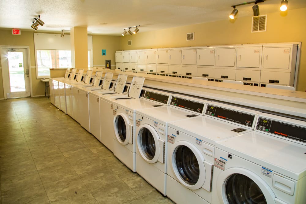 A laundry room with plenty of machines at Sunbrook Apartments in Saint Charles, Missouri