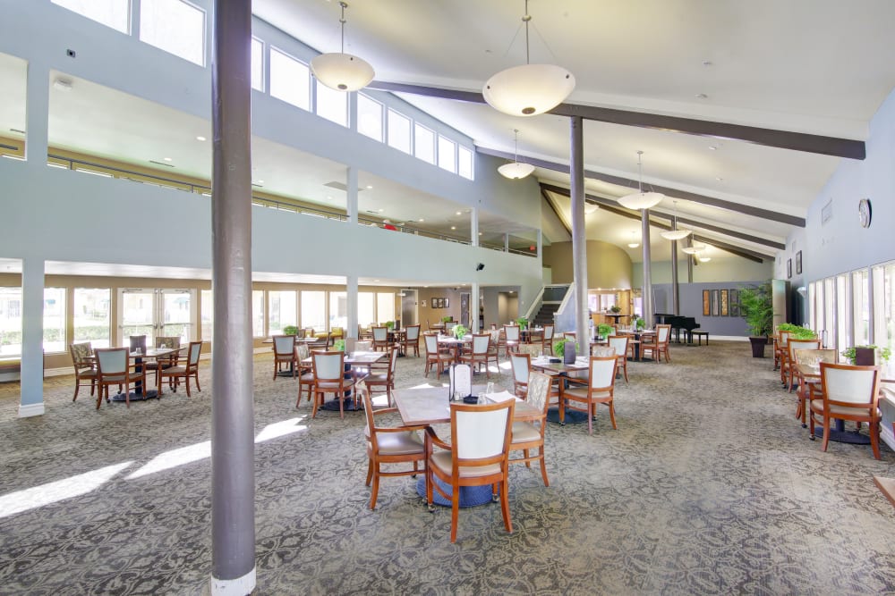 Dining hall with carpeted floors and a very tall ceiling at Citrus Place in Riverside, California