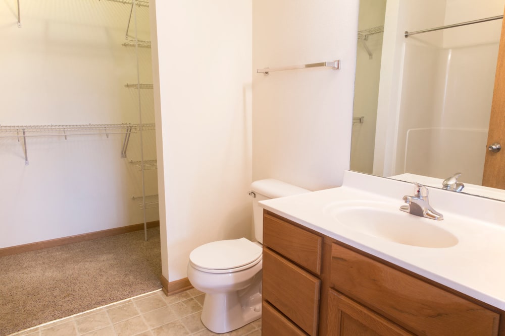 Bathroom with a walk in closet and stacked washer and dryer at Westwood Village in Ames, Iowa