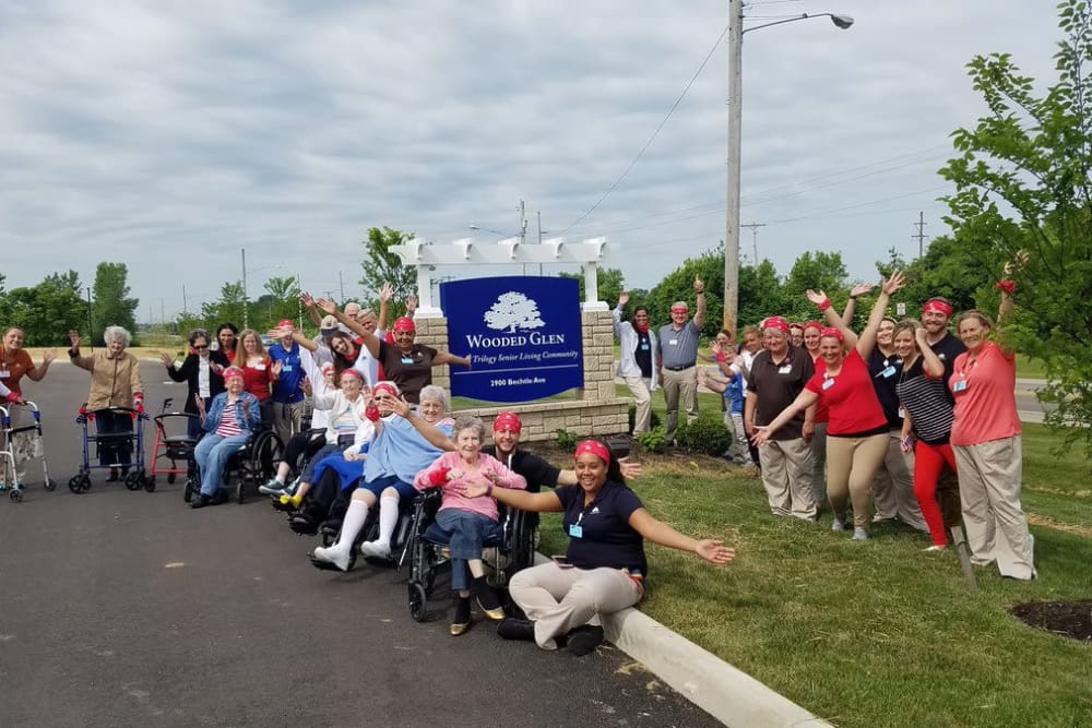 Residents and staff next to the main sign for Wooded Glen Health Campus in Springfield, Ohio