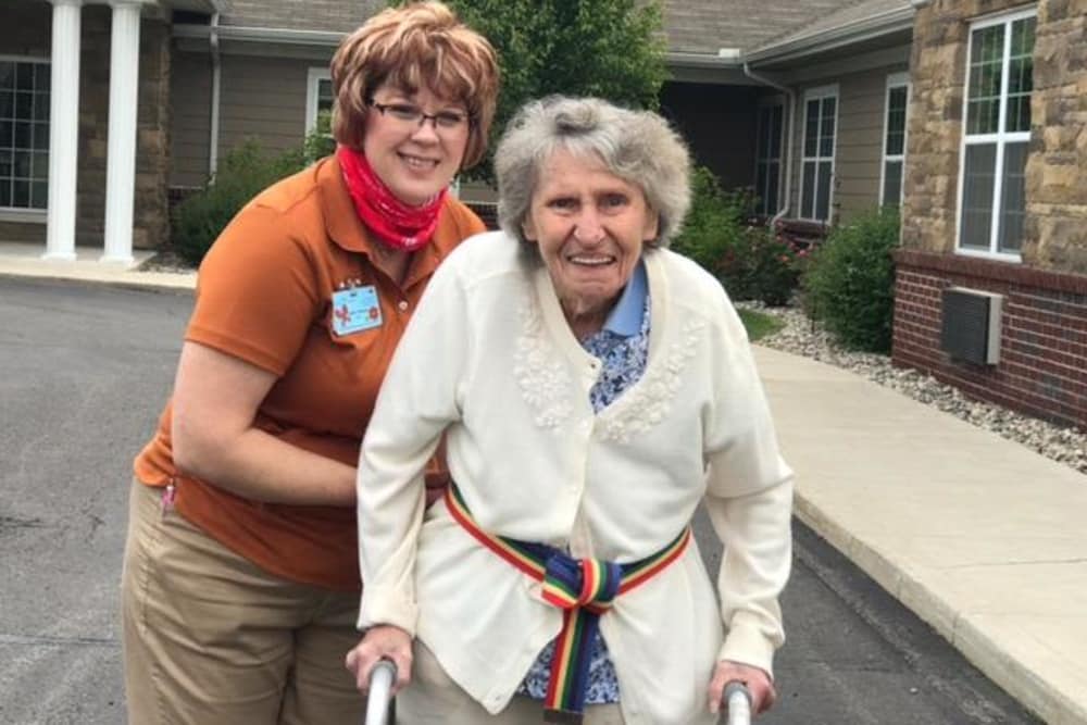 Female resident and staff member taking a stroll outside at Shelby Crossing Health Campus in Shelby Township, Michigan