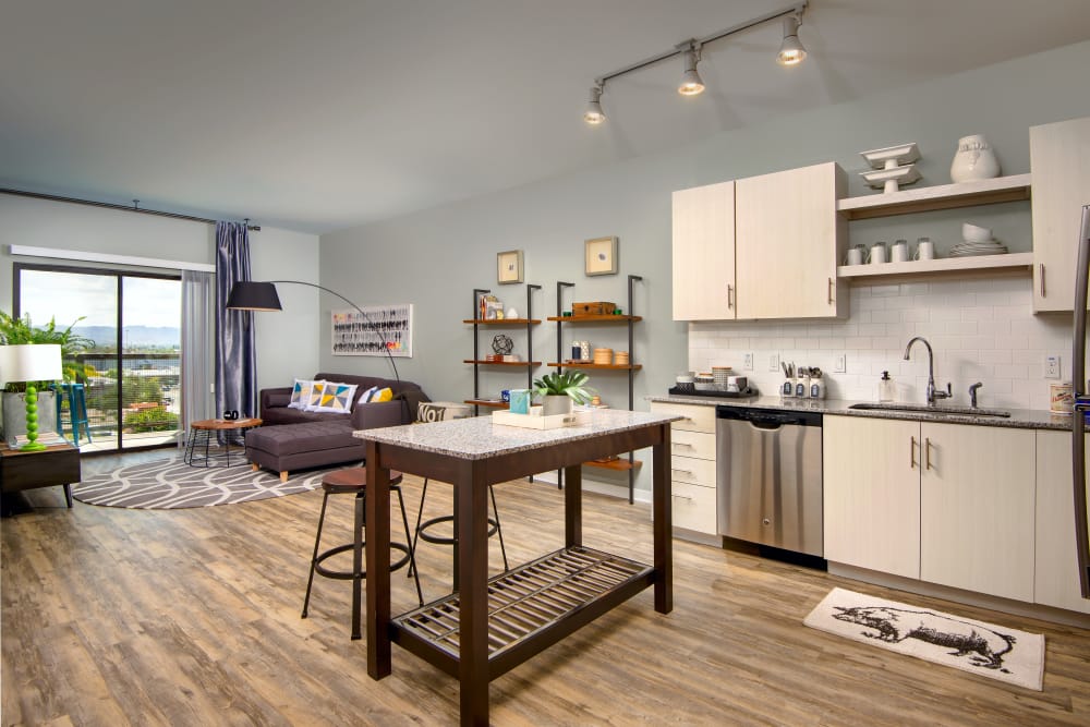 Kitchen with and living area with hardwood floors in open-concept floor plan of model home at Capital Place in Phoenix, Arizona