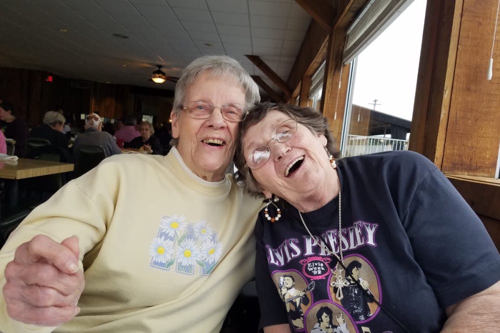 Two female residents smiling for the camera while at lunch at StoneBridge Health Campus in Bedford, Indiana