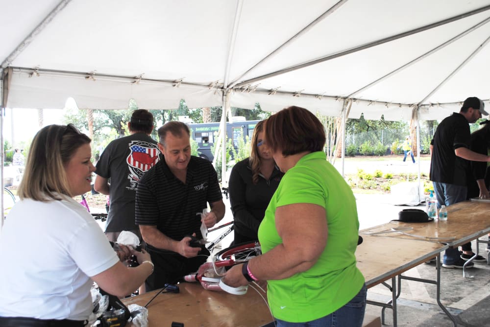 Employees volunteering at a booth for a local event near WRH Realty Services, Inc