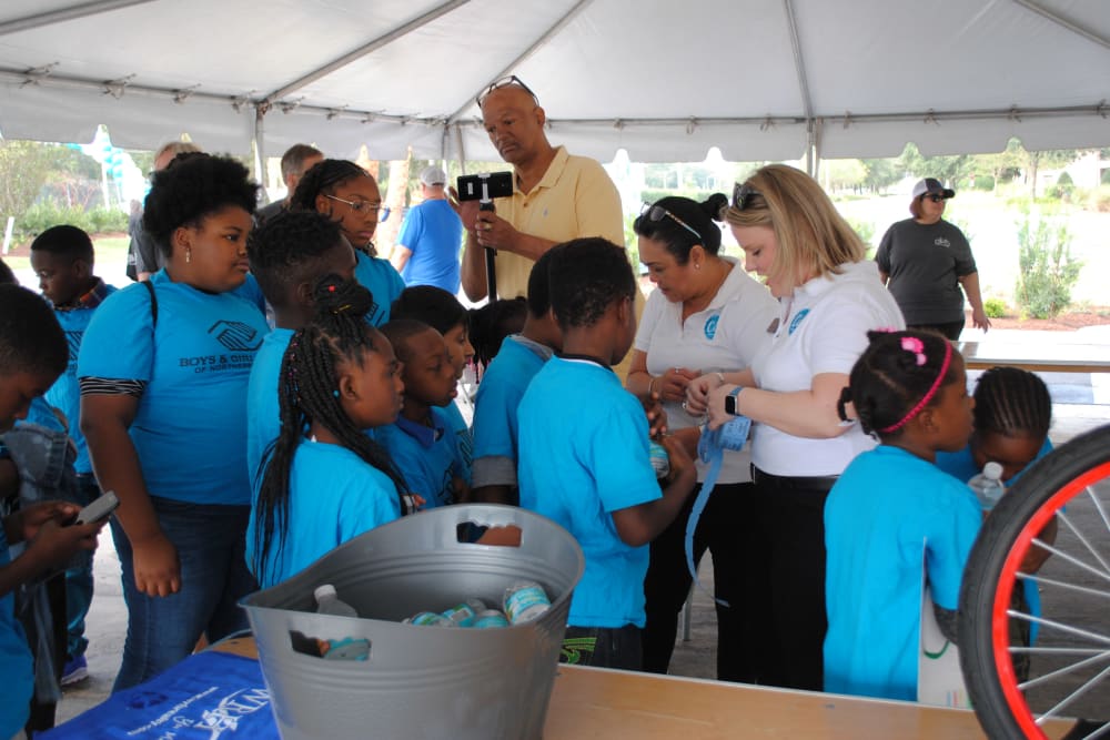 Employees gather with children at a community event near  WRH Realty Services, Inc 