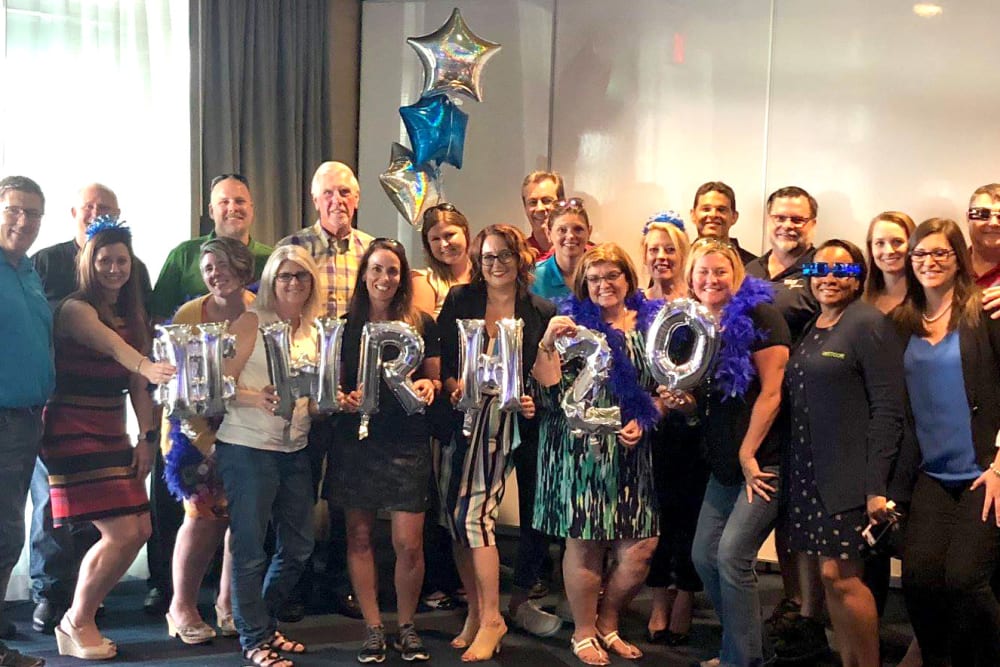 WRH Realty Services, Inc employees pose for a group photo at a company celebration