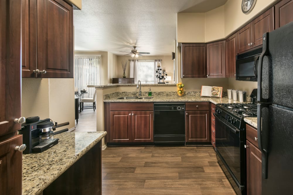Gourmet kitchen with granite countertops and adjacent workspace in model home at Laguna at Arrowhead Ranch in Glendale, Arizona