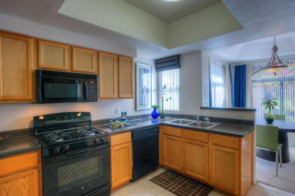 Modern kitchen with sleek black appliances in a model home at San Pedregal in Phoenix, Arizona