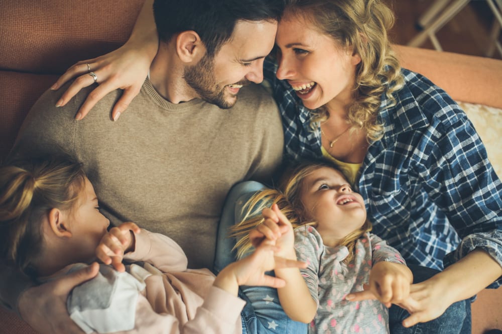Family cuddling on a bed at The Trails at Canyon Crest in Riverside, California