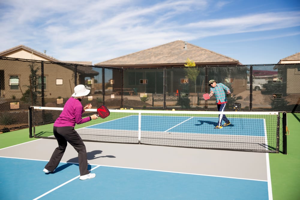 Two residents playing tennis at Touchmark Health & Fitness Club in Meridian, Idaho