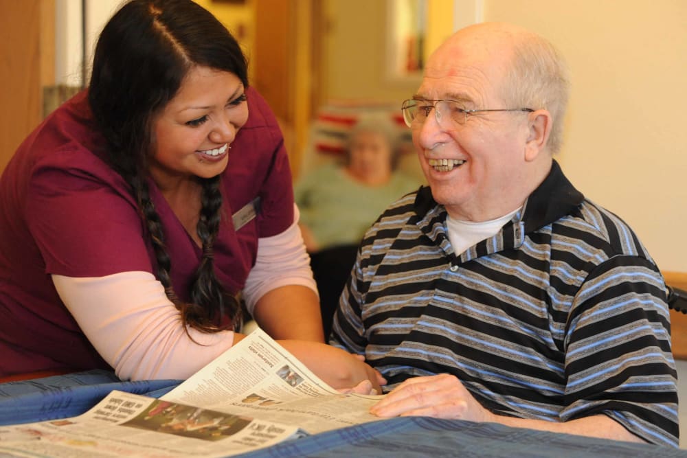 A caretaker reading the paper with her patient at Chandler House in Yakima, Washington