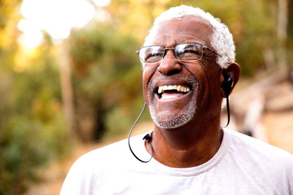 A happy resident laughing outside at The Courtyards at Linden Pointe in Winnipeg, Manitoba