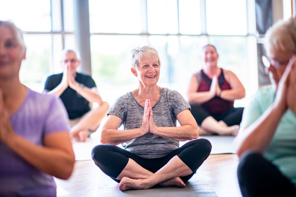 A group of residents performing a yoga pose at Brightwater Senior Living of Linden Ridge in Winnipeg, Manitoba