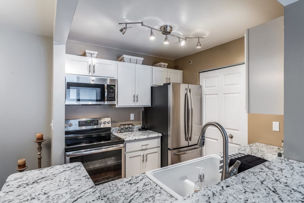 Kitchen with granite counter-tops at Waters Edge Apartments in Lansing, Michigan
