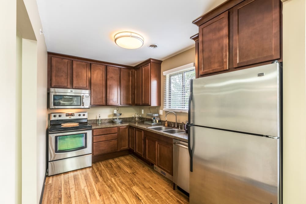 Kitchen with wood cabinetry at Waters Edge Apartments in Lansing, Michigan