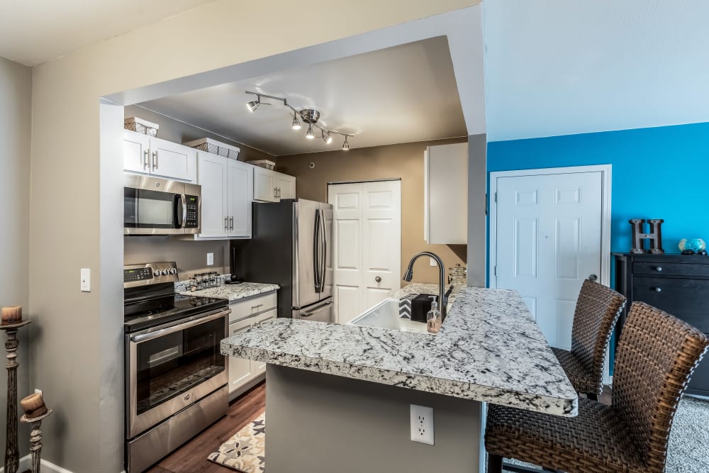 Kitchen with blue accent wall at Waters Edge Apartments in Lansing, Michigan