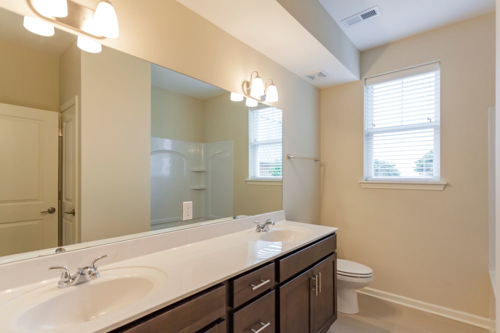 Bathroom featuring a double sink vanity with dark wood cabinets at Madison Crest Apartment Homes in Madison, Tennessee