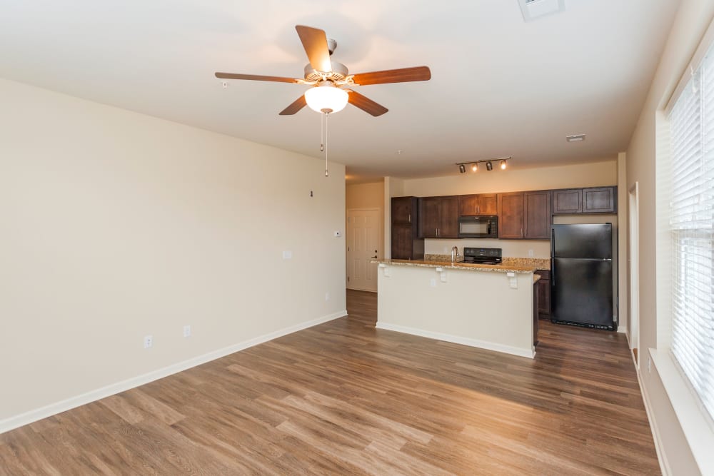 Living area with hardwood floors and a ceiling fan at Madison Crest Apartment Homes in Madison, Tennessee