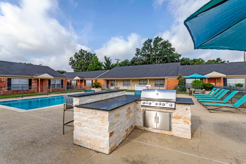 Barbecue station by the pool at Willow Oaks Apartments in Bryan, Texas