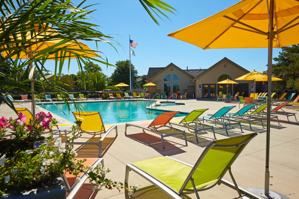 Resort-style swimming pool with colorful lounge chairs and umbrellas at Lakeside Terraces in Sterling Heights, Michigan