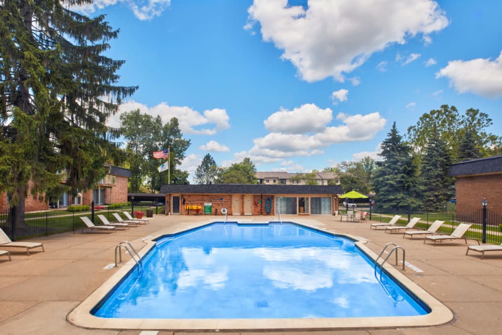 Sparkling swimming pool and expansive pool deck at Kensington Manor Apartments in Farmington, Michigan